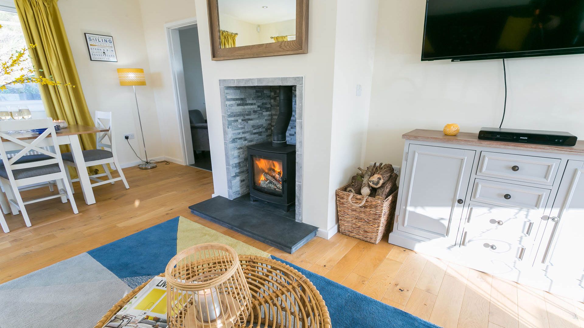 Living room with wood-burning stove and comfortable seating at Bron Heulog